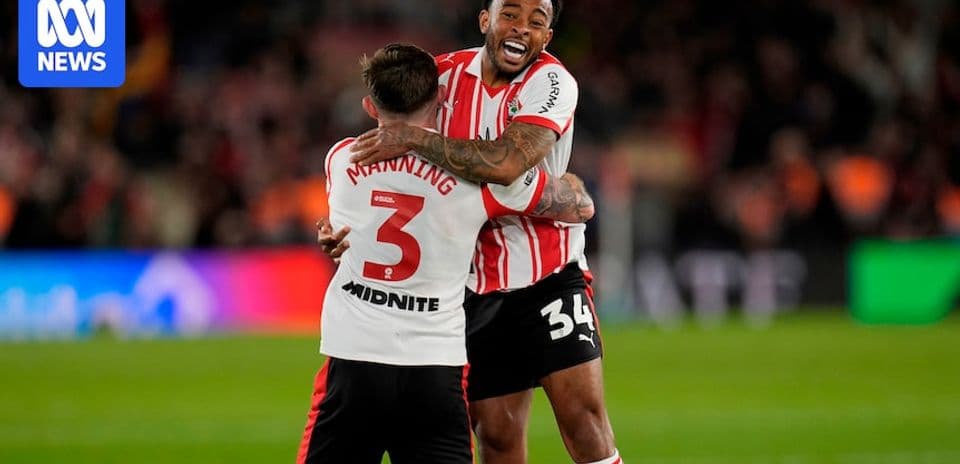 Two players celebrating with a hug on field