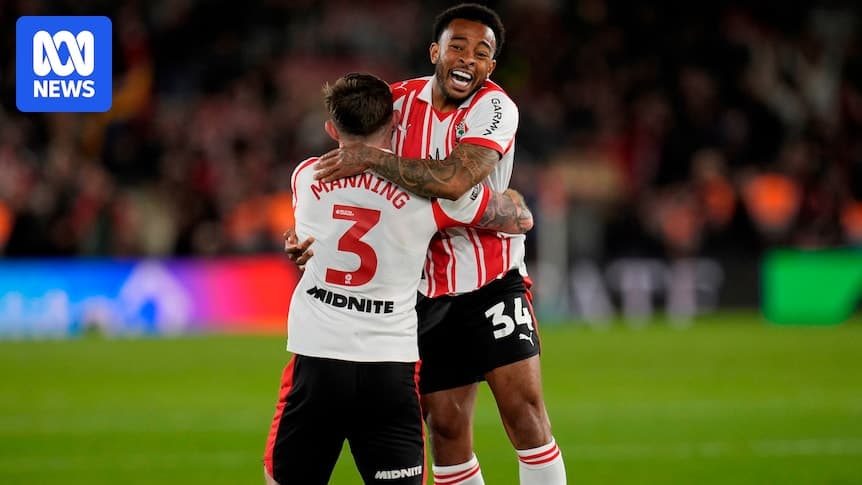 Two players celebrating with a hug on field