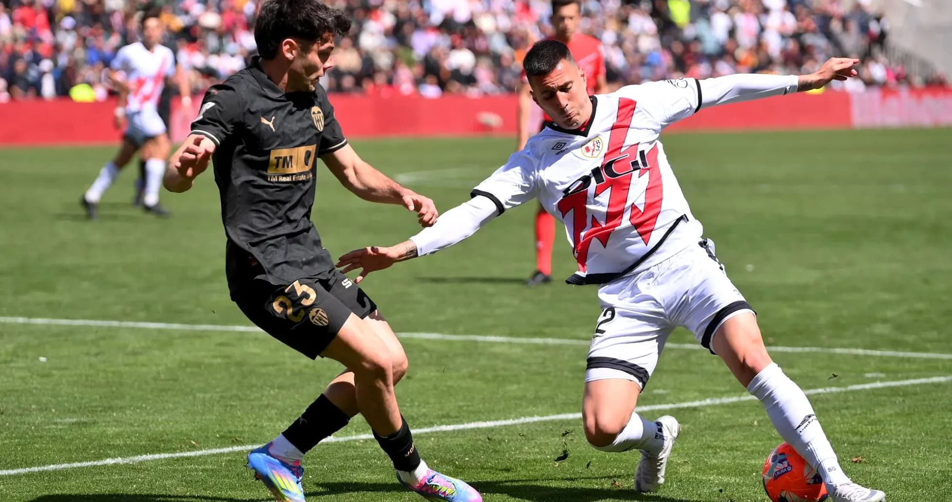 Valencia player tackling Rayo Vallecano opponent
