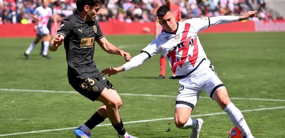 Valencia player tackling Rayo Vallecano opponent