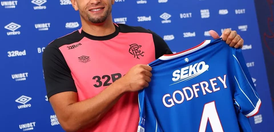 Player holding new jersey during signing event