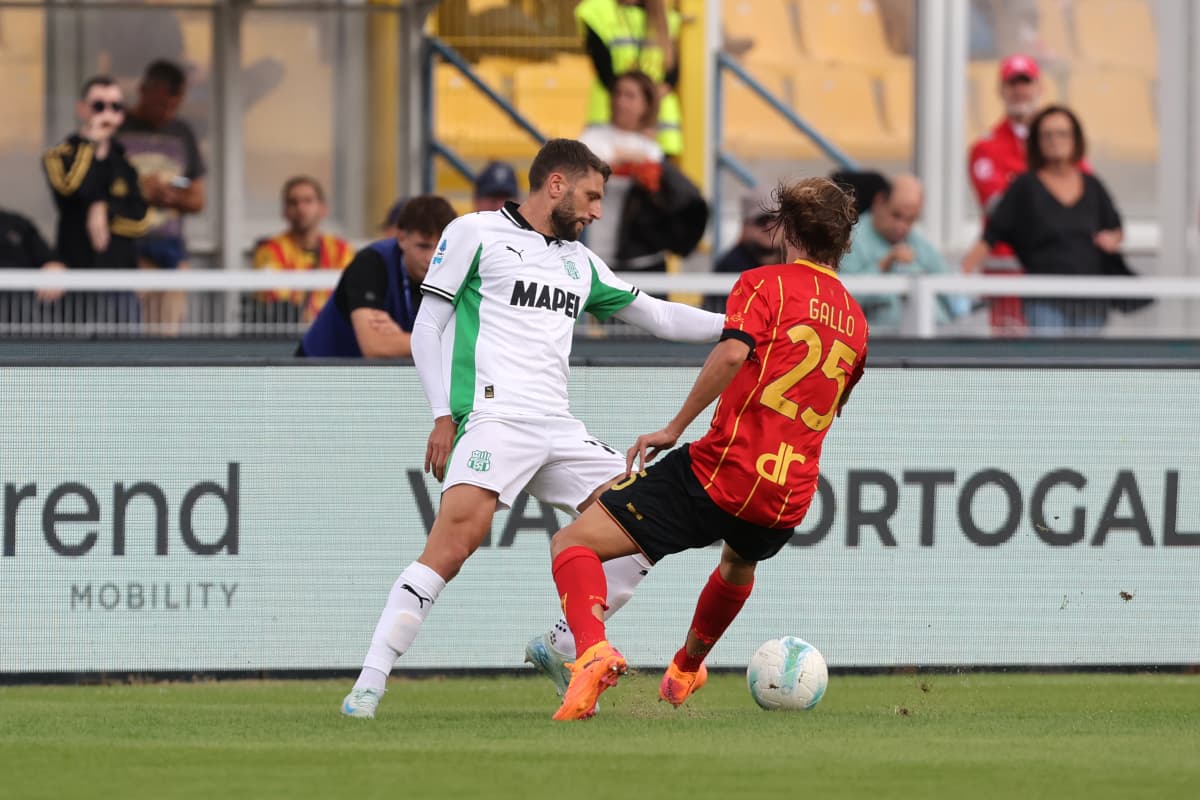 Sassuolo player tackling Lecce opponent during match