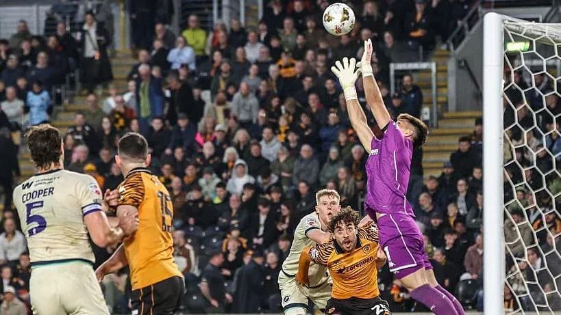 Goalkeeper jumping to catch a high ball during match