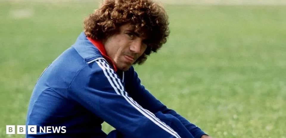 Athlete in blue tracksuit sitting on grass
