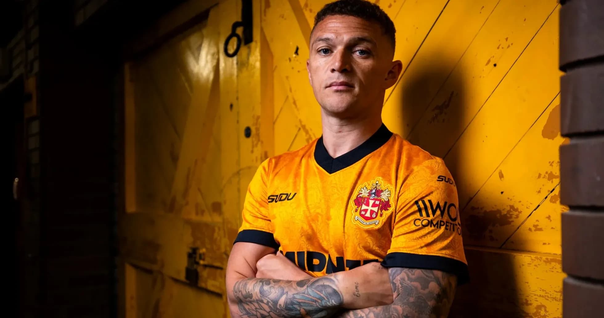 Player posing in orange team jersey against yellow background