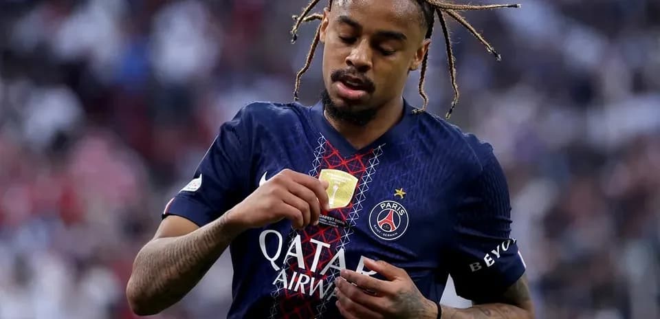 Player inspecting medal while wearing PSG jersey