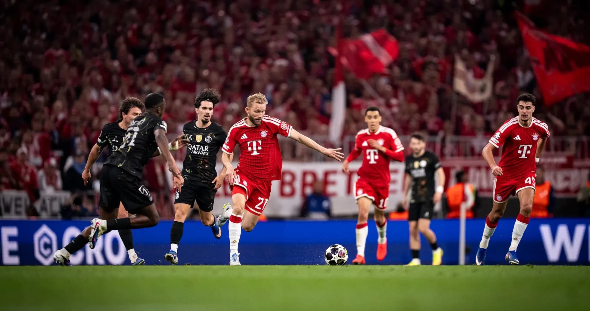 Bayern player dribbling past PSG defenders
