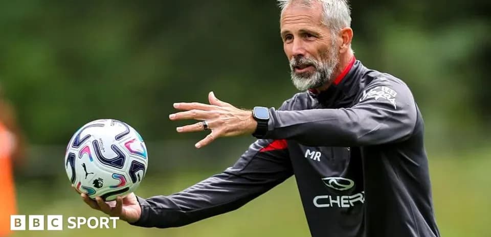 Coach instructing players while holding a football