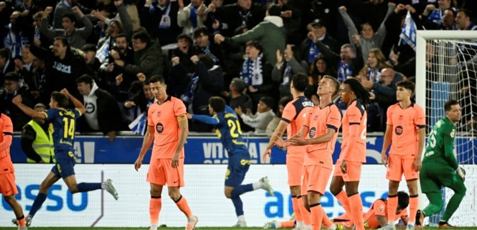 Players reacting to a goal with fans celebrating