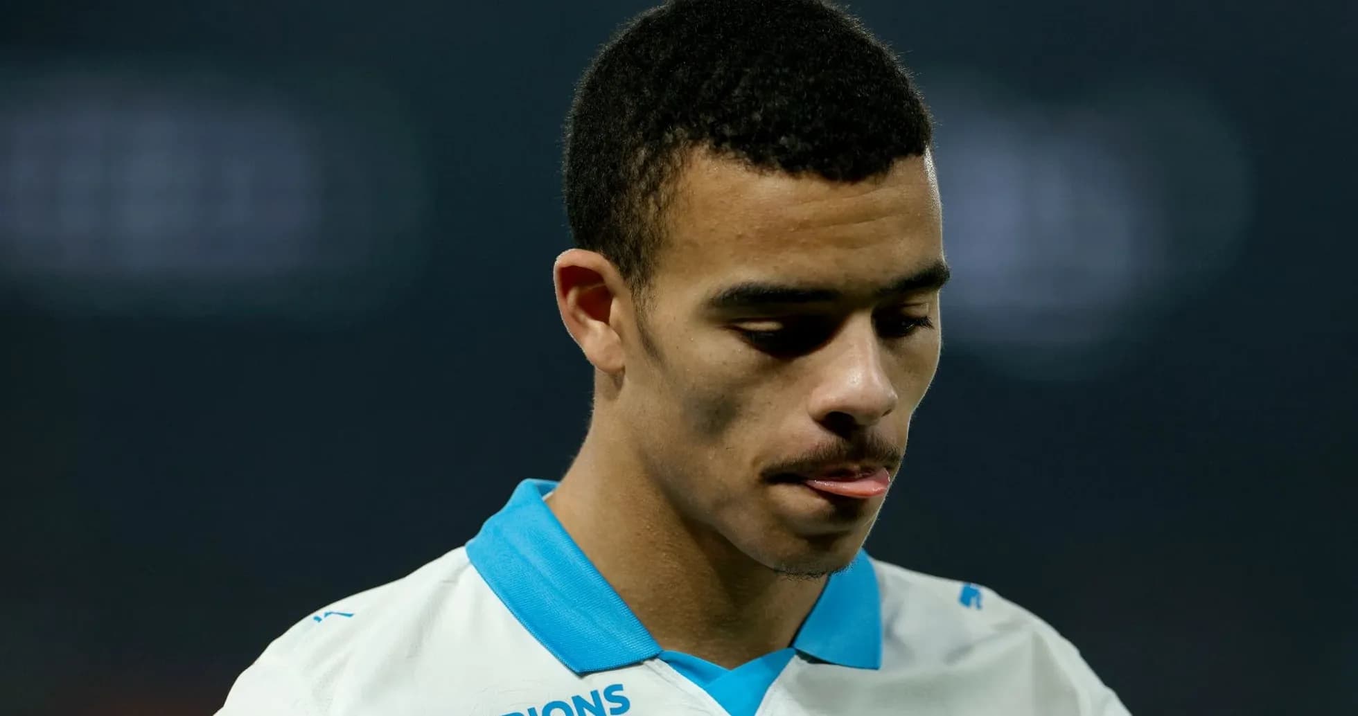 Player looking down during match, wearing team jersey