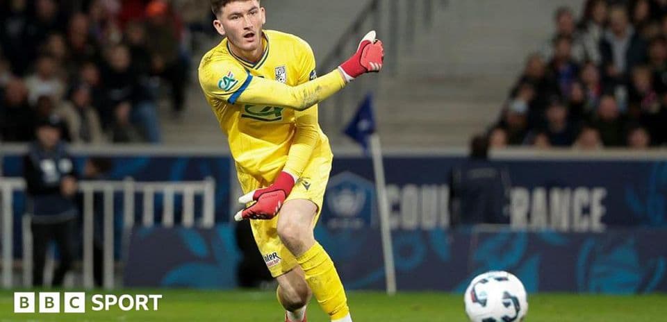 Goalkeeper in yellow kit preparing to kick ball