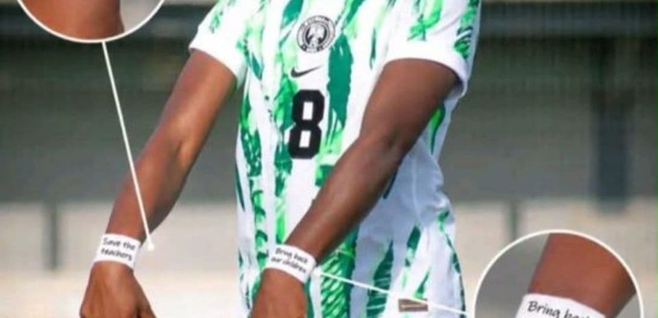 Player wearing Nigeria jersey with protest messages on arms