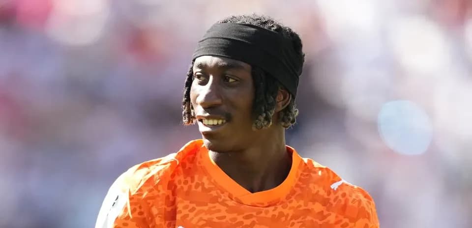 Goalkeeper in orange jersey during warm-up