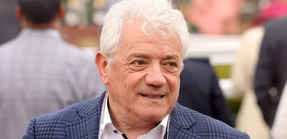 Man with white hair in a checkered jacket