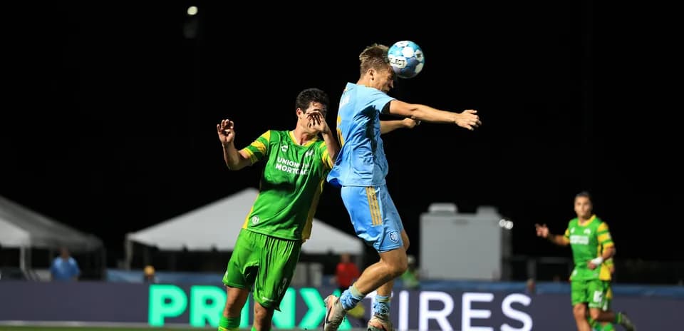 Player heading the ball during JAX vs Rowdies match