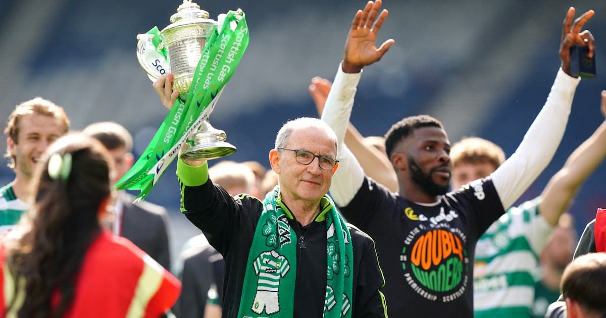 Man holding trophy with team celebrating in background