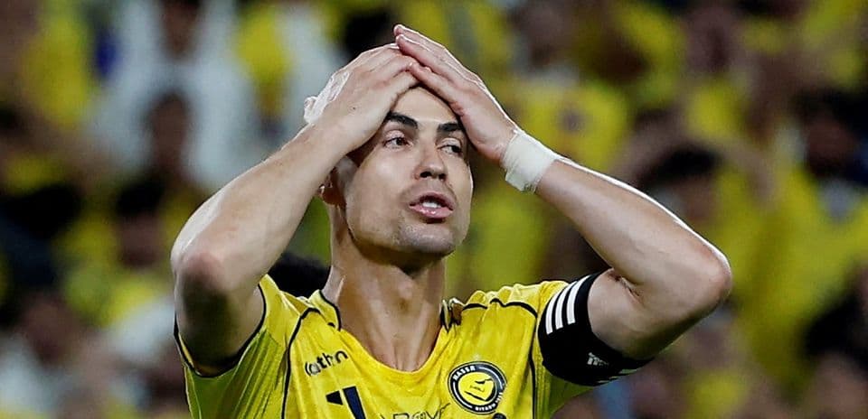 Player in yellow jersey with hands on head