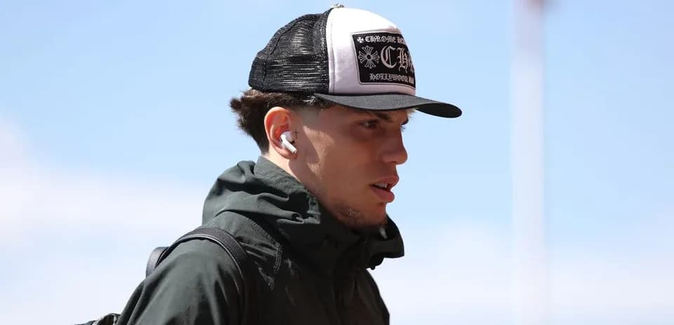Player wearing a cap and earbuds walking outdoors