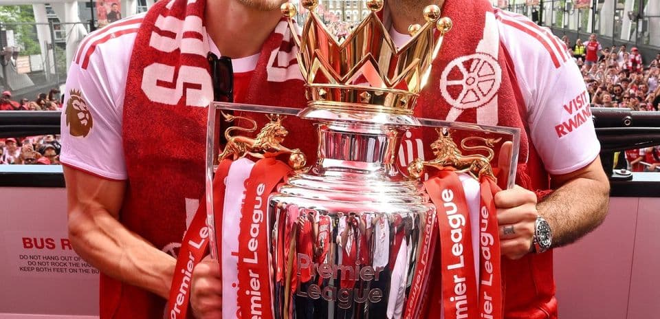 Players celebrating with Premier League trophy on stage