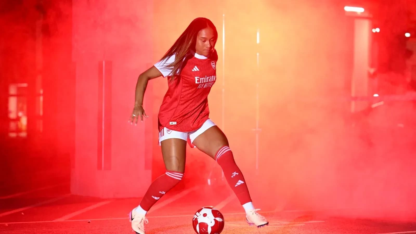 Player in Arsenal kit preparing to kick soccer ball