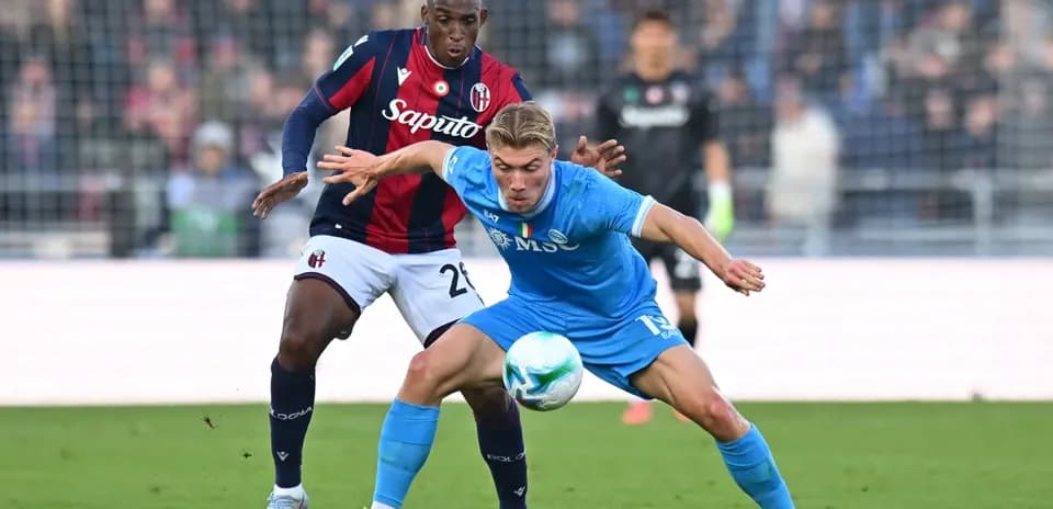 Napoli player challenging Bologna defender for the ball