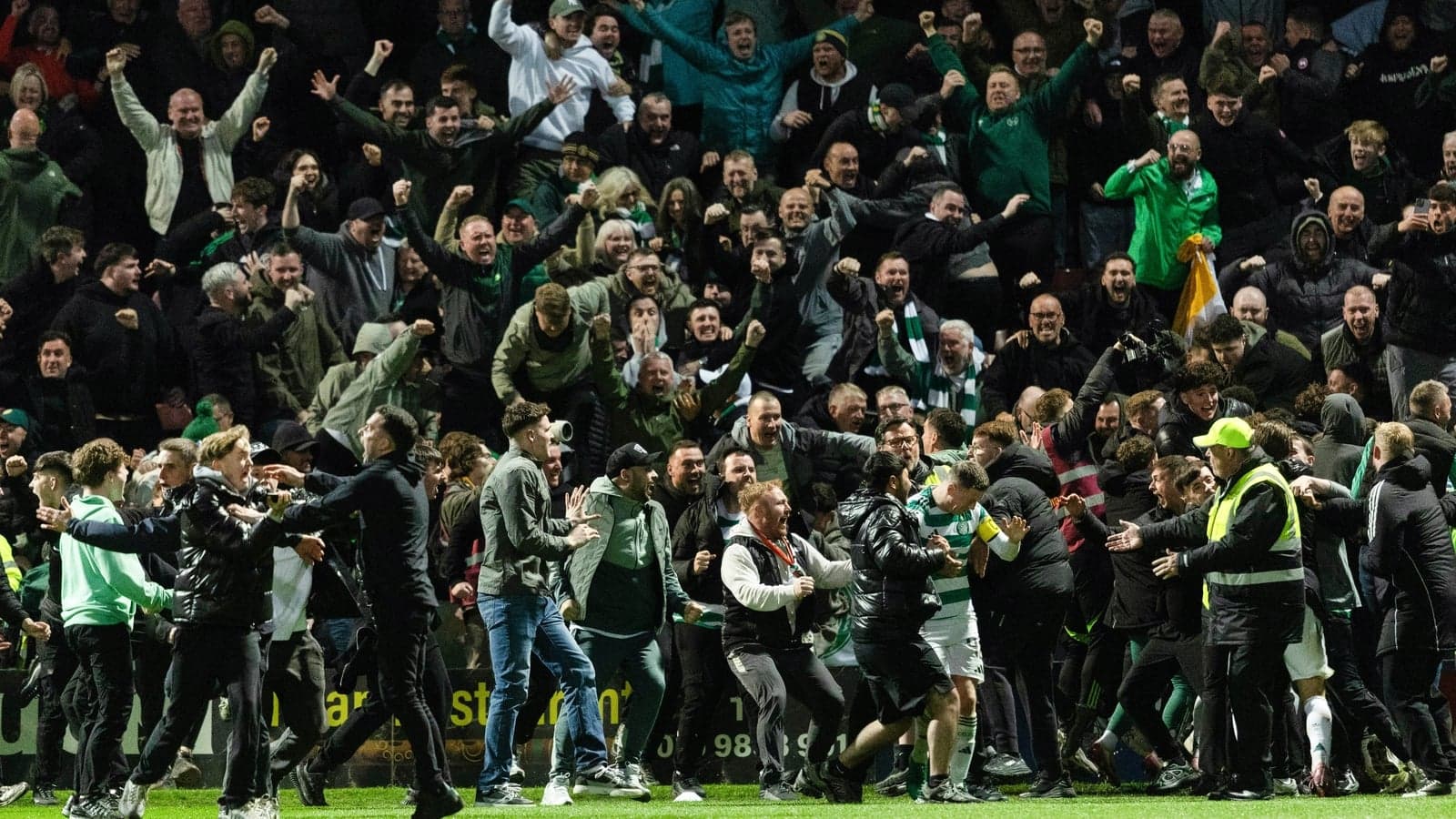 Fans celebrating on the pitch after a match