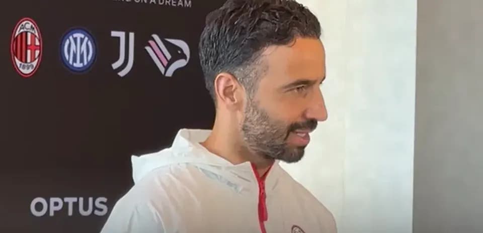 Man in AC Milan jacket during press event