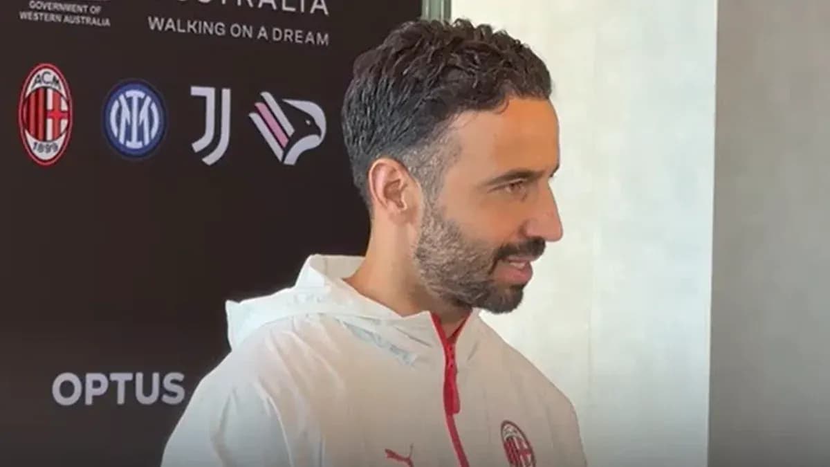 Man in AC Milan jacket during press event