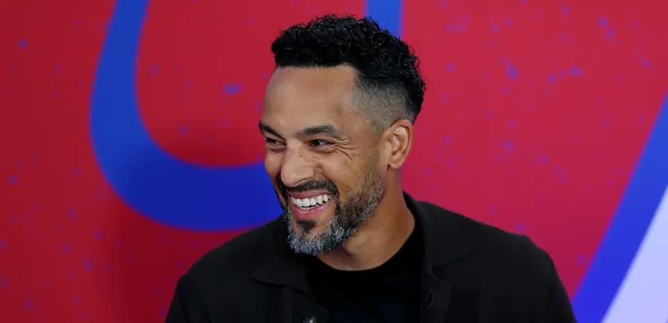 Man smiling during an event with colorful background