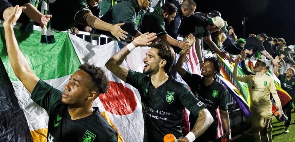 Lexington players celebrating with fans after match
