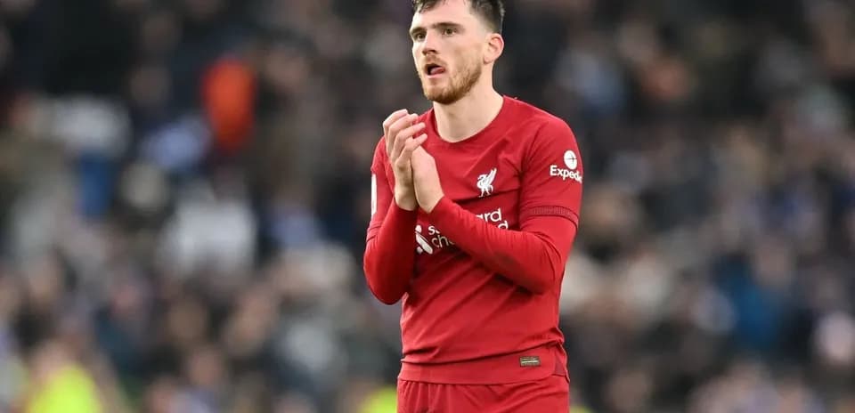 Player in red jersey applauding fans after match