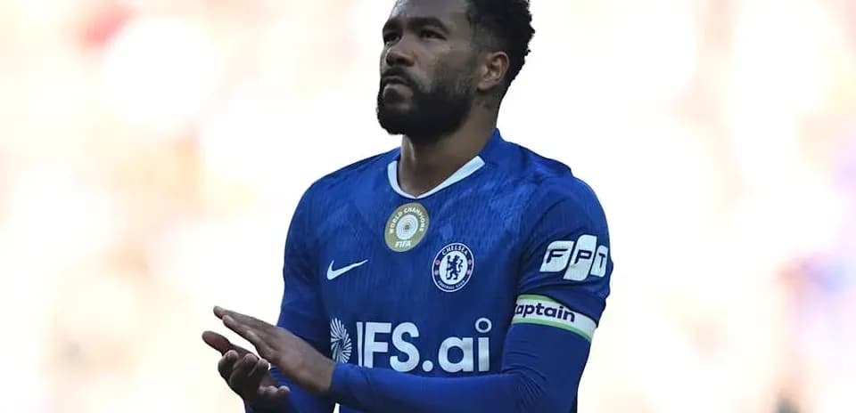 Player in blue jersey with captain's armband clapping