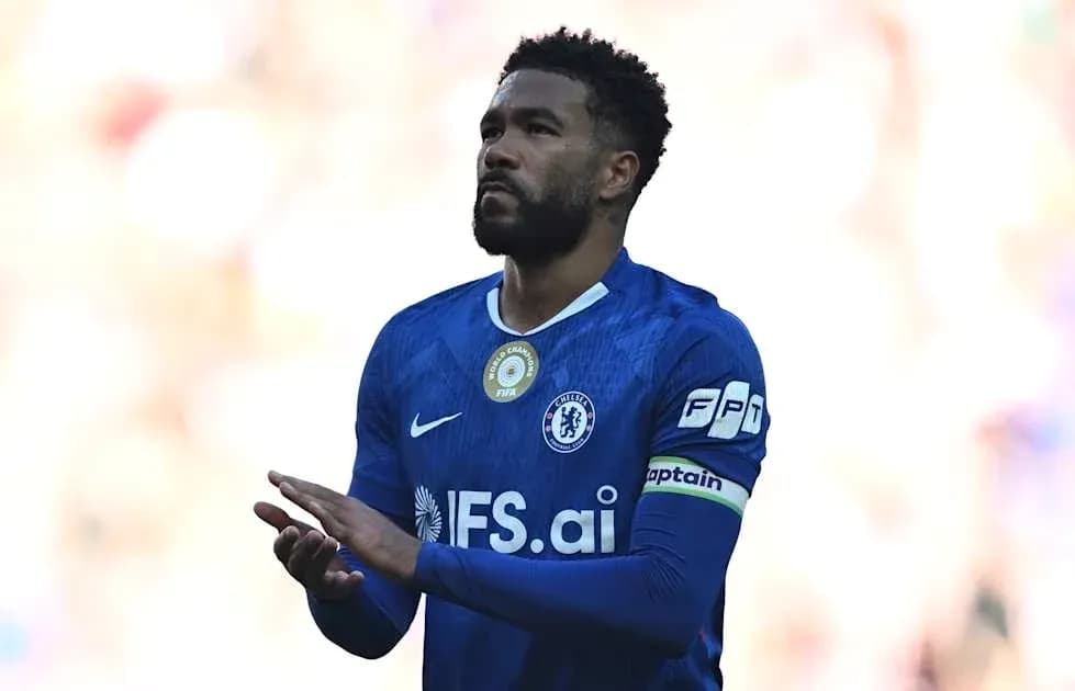 Player in blue jersey with captain's armband clapping