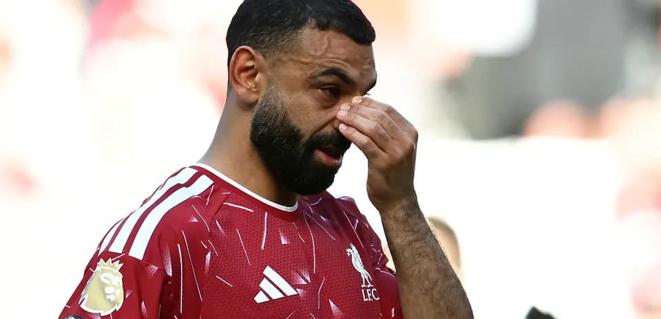 Player in Liverpool jersey wiping his face