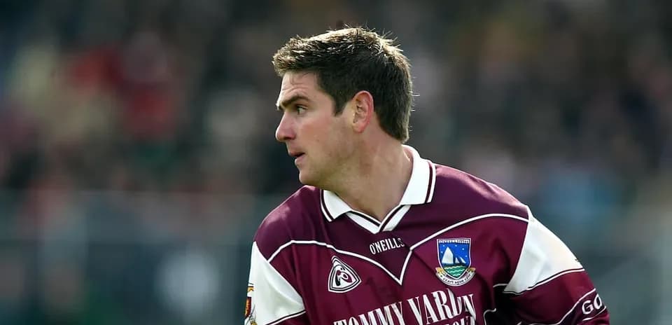 Player in maroon jersey running during a match
