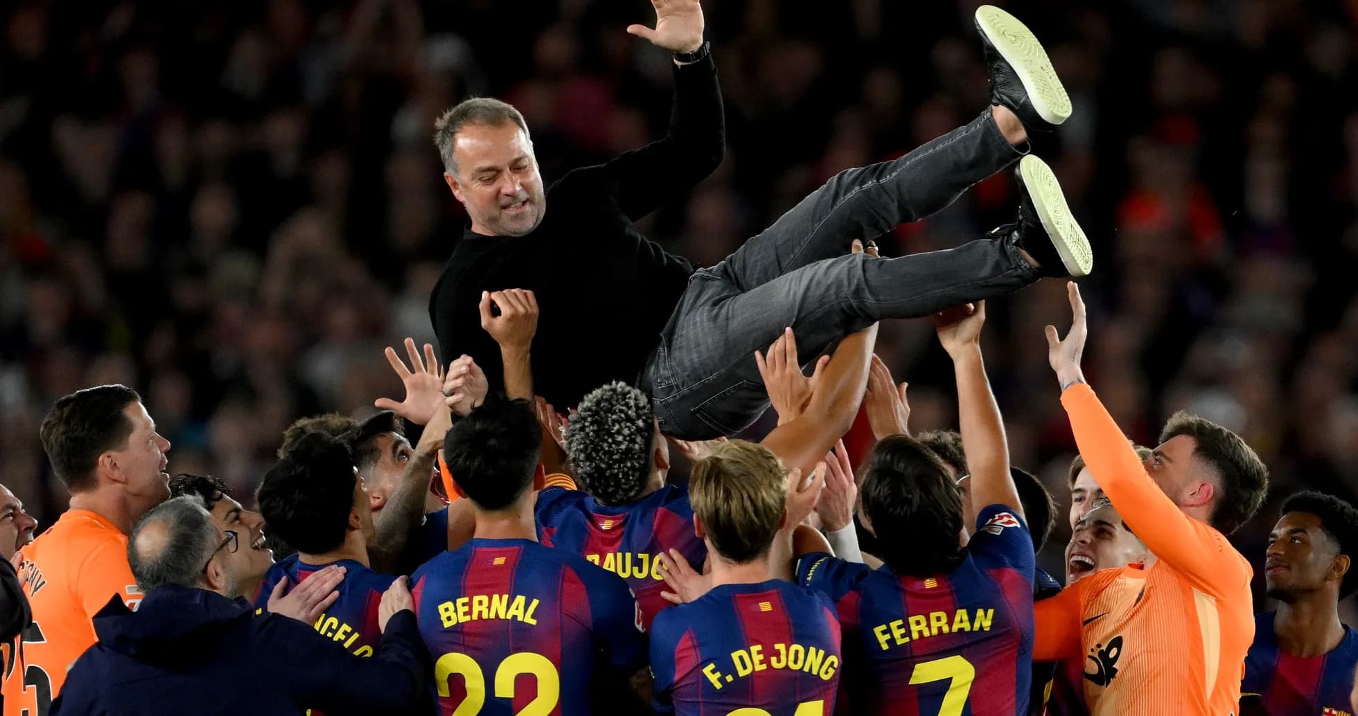 Barcelona players celebrating by lifting their coach