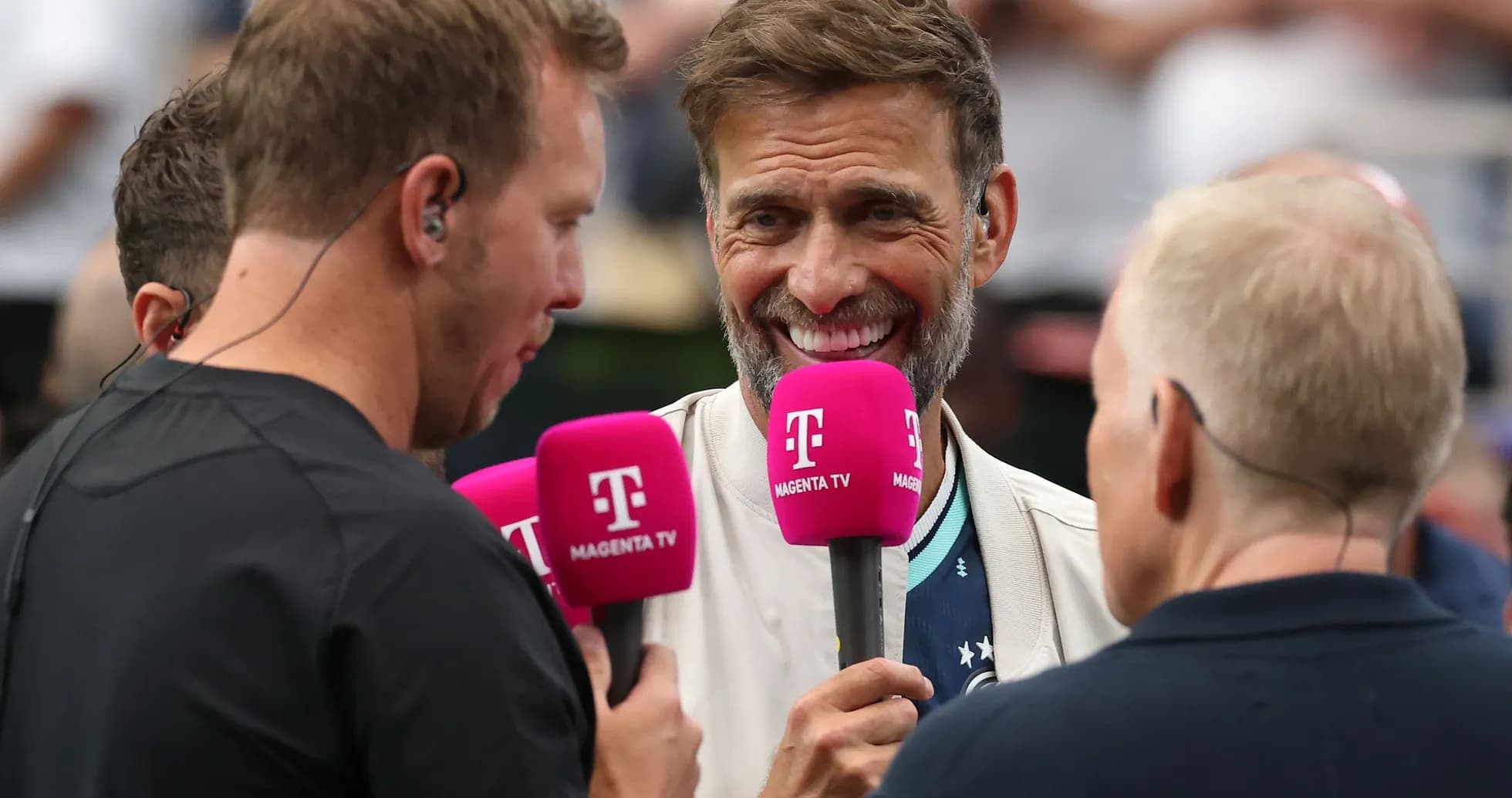 Group of presenters discussing with microphones at event