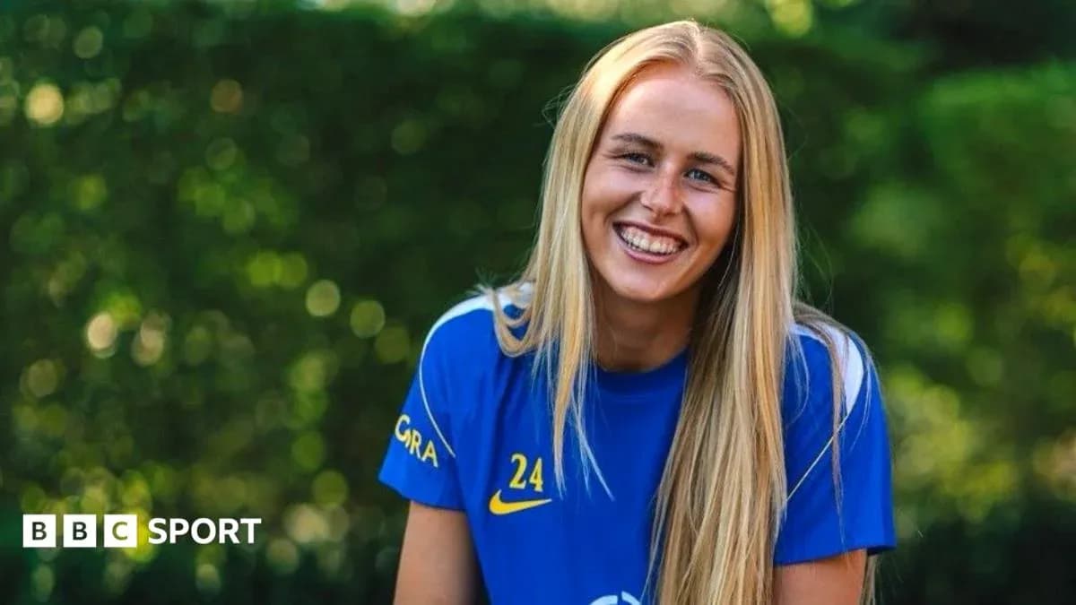 Female athlete smiling in blue sports jersey