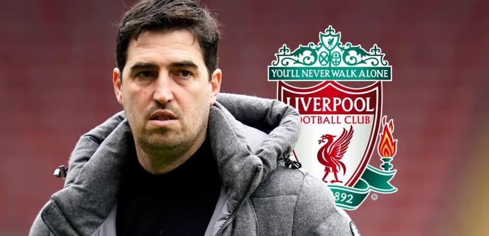 Man in a jacket near Liverpool FC logo