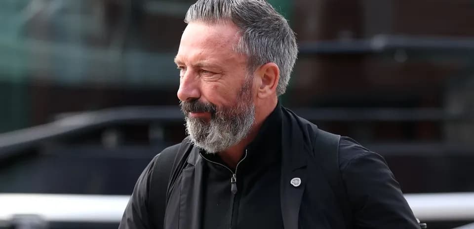 Man with beard walking outside near vehicle