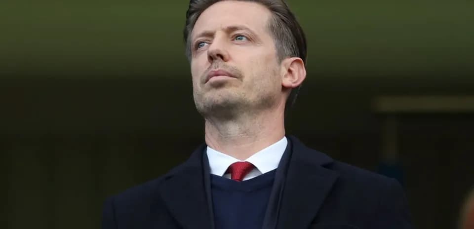Man in suit observing from a stadium box