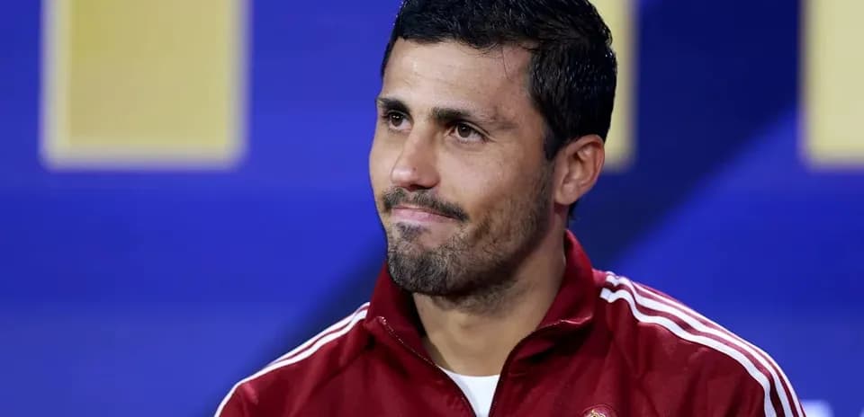 Football player in red training jacket at press conference