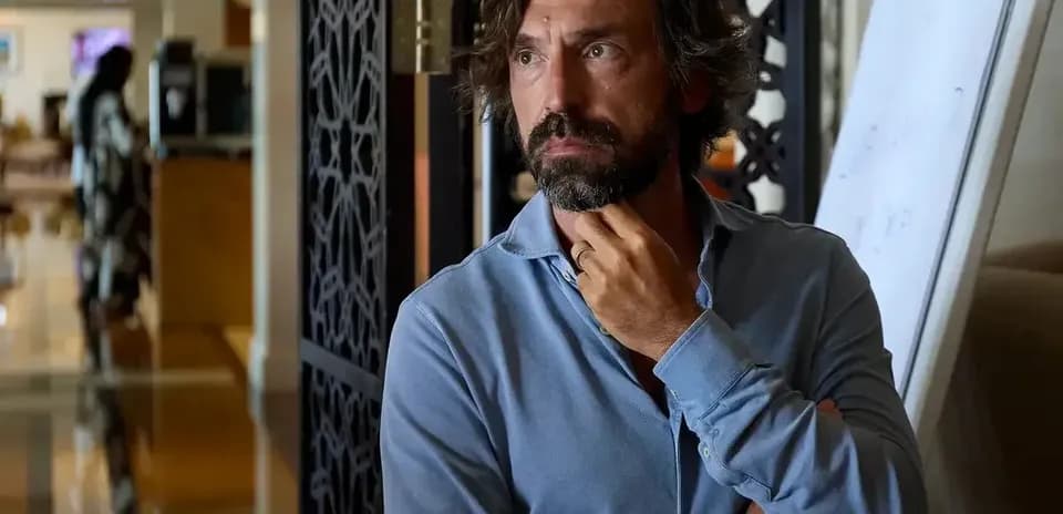 Man in blue shirt standing pensively indoors