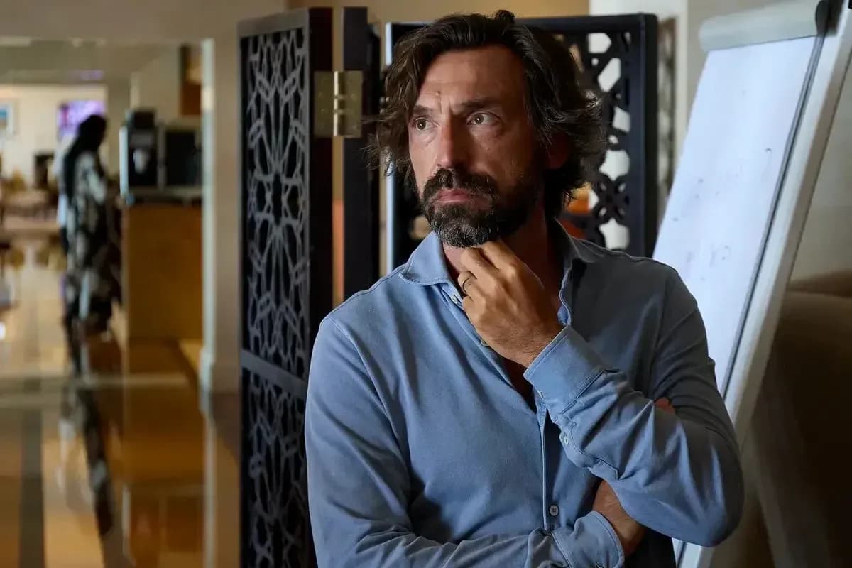 Man in blue shirt standing pensively indoors