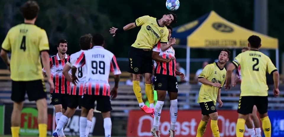 Charleston Battery player heading the ball during match