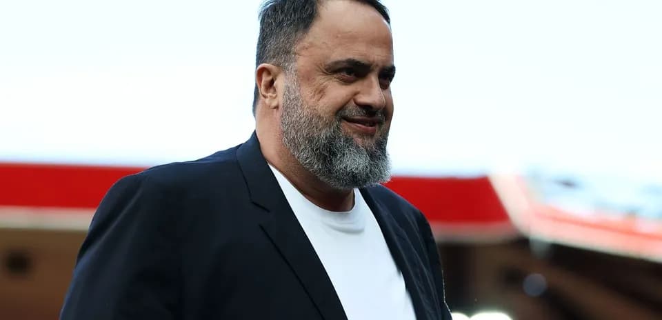 Man with beard walking in a stadium setting