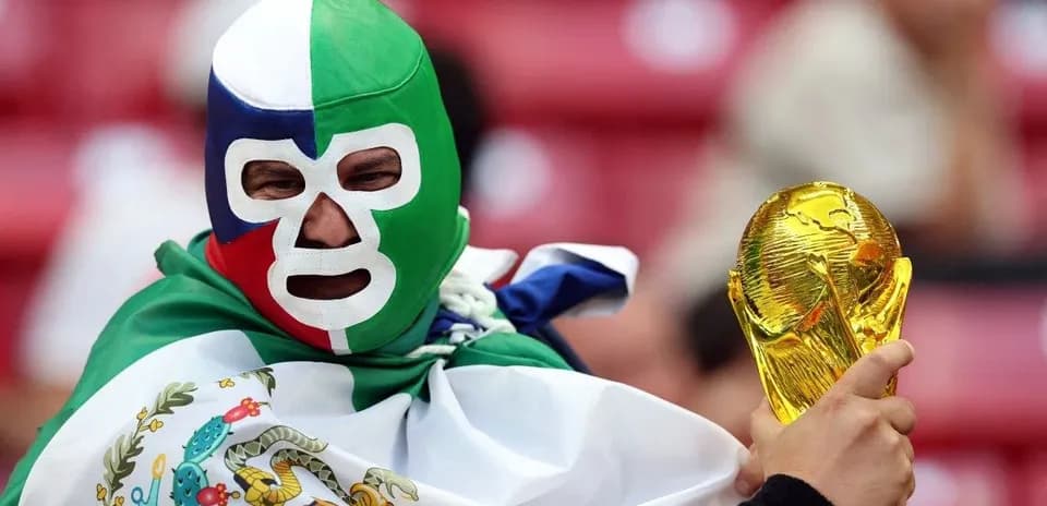 Fan wearing mask holding World Cup trophy