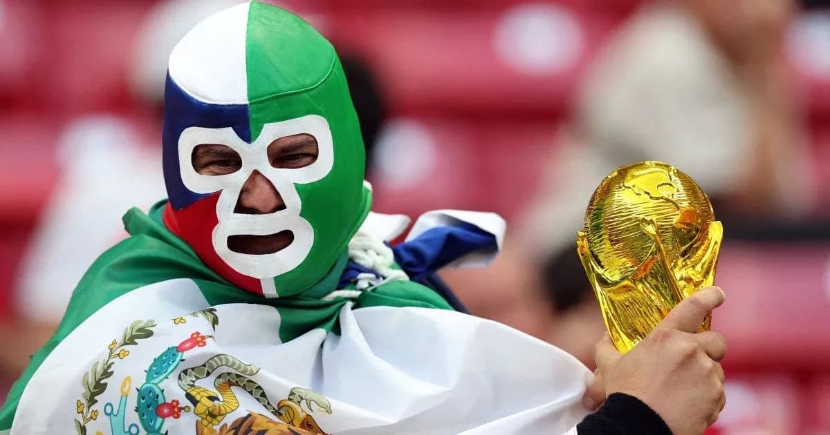 Fan wearing mask holding World Cup trophy