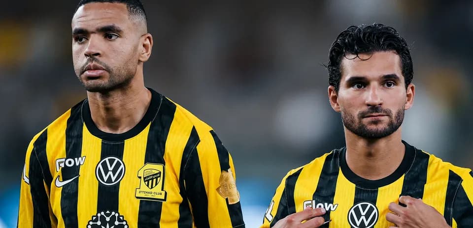 Two players in black and yellow jerseys looking focused