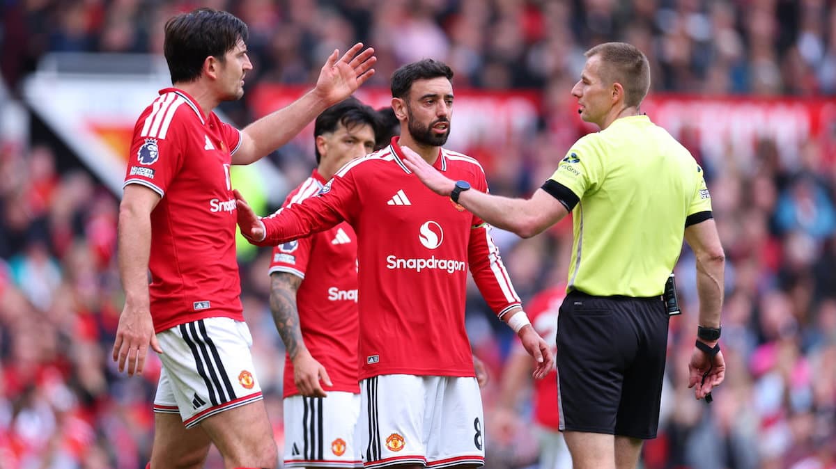Manchester United players discussing with the referee